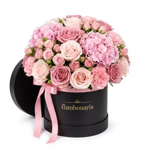 Soft pink roses and hydrangea in a black flambouayia hat box with pink ribbon